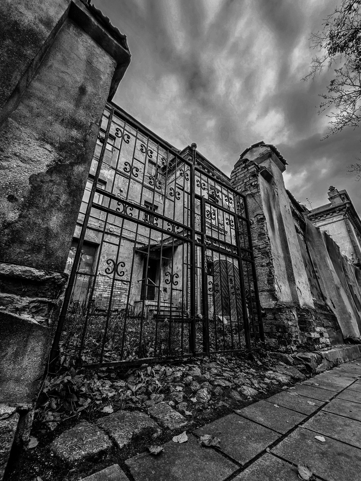 An old gate seen from a low angle beneath a dramatic sky