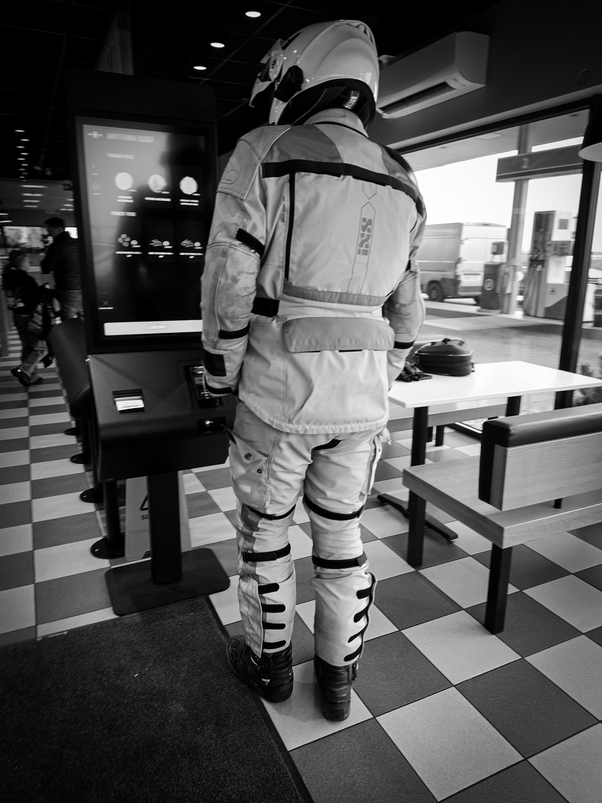 Motorcyclist standing at a restaurant ordering screen